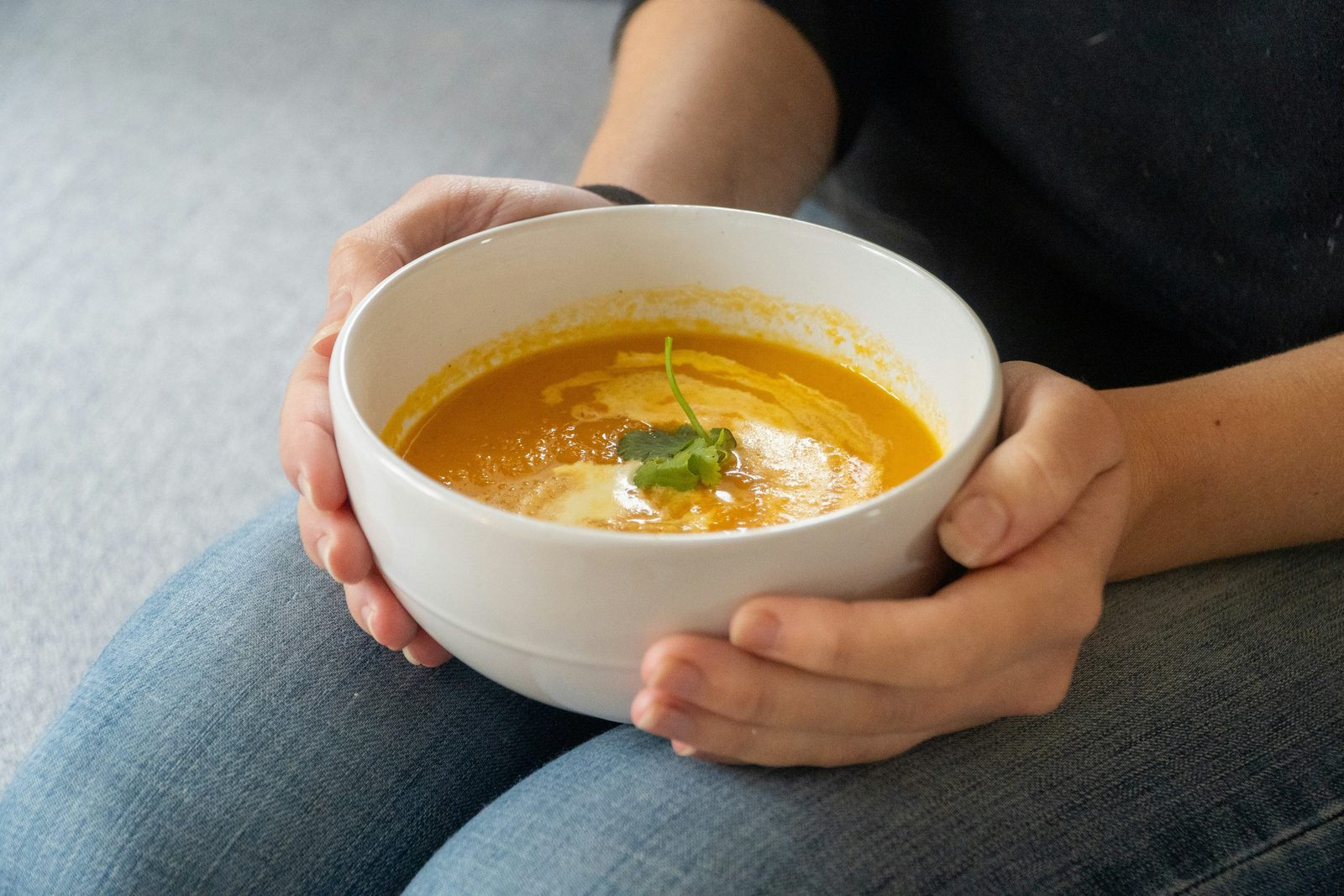 Hands holding a warm bowl of soup: herbal medicine for digestive health in Waimea and Kona, Hawaii