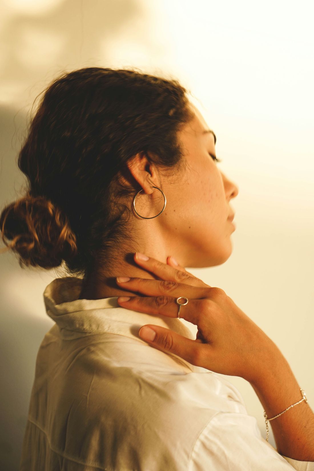 Woman with eyes closed, easing tension in her neck and shoulder